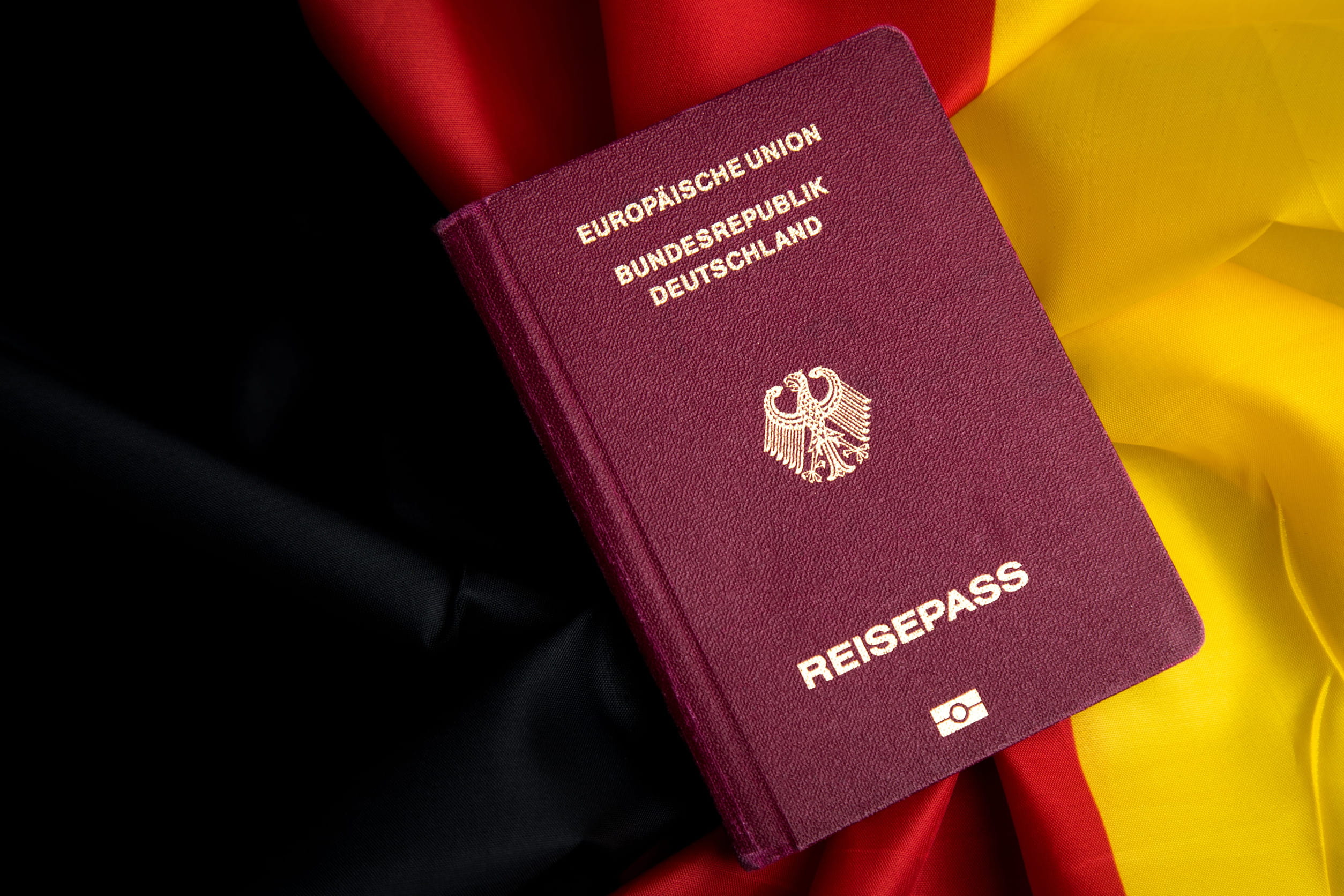 German Passport On Flag Of Federal Republic Of Germany