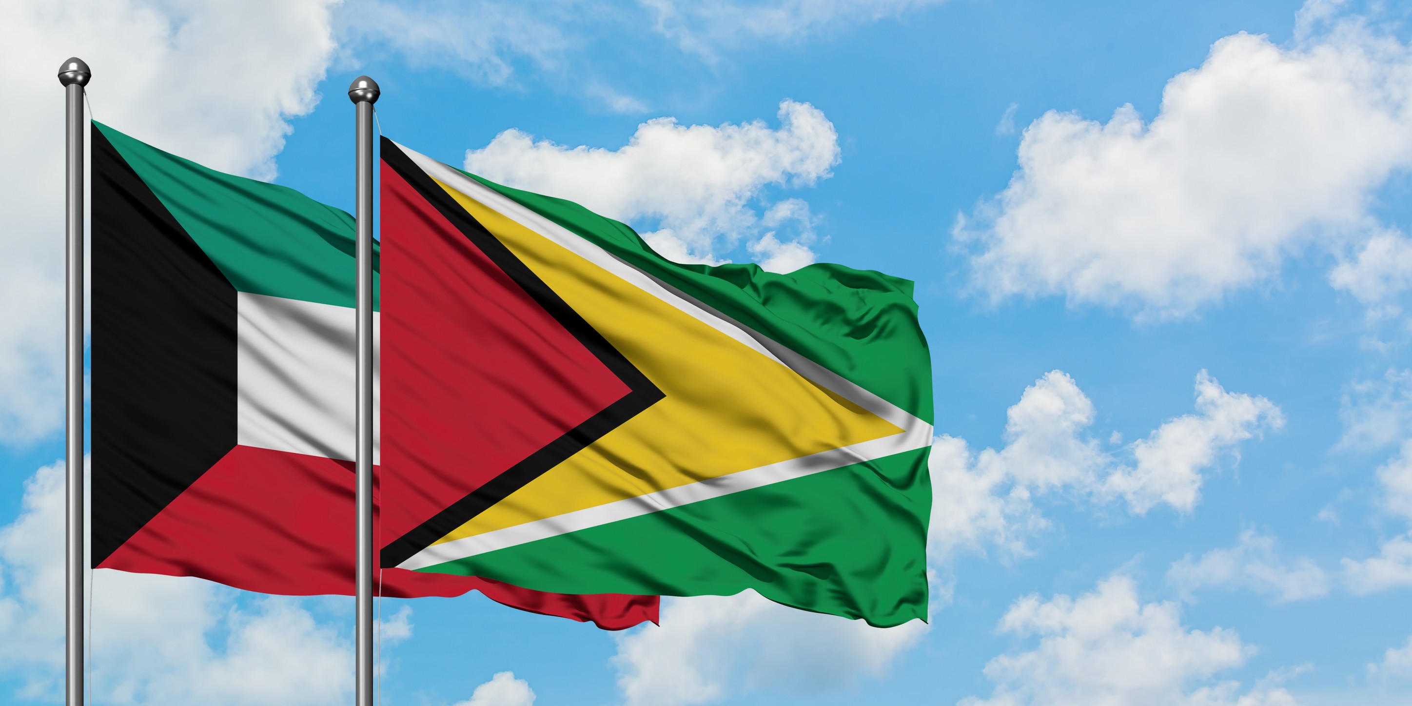 Kuwait And Guyana Flag Waving In The Wind Against
