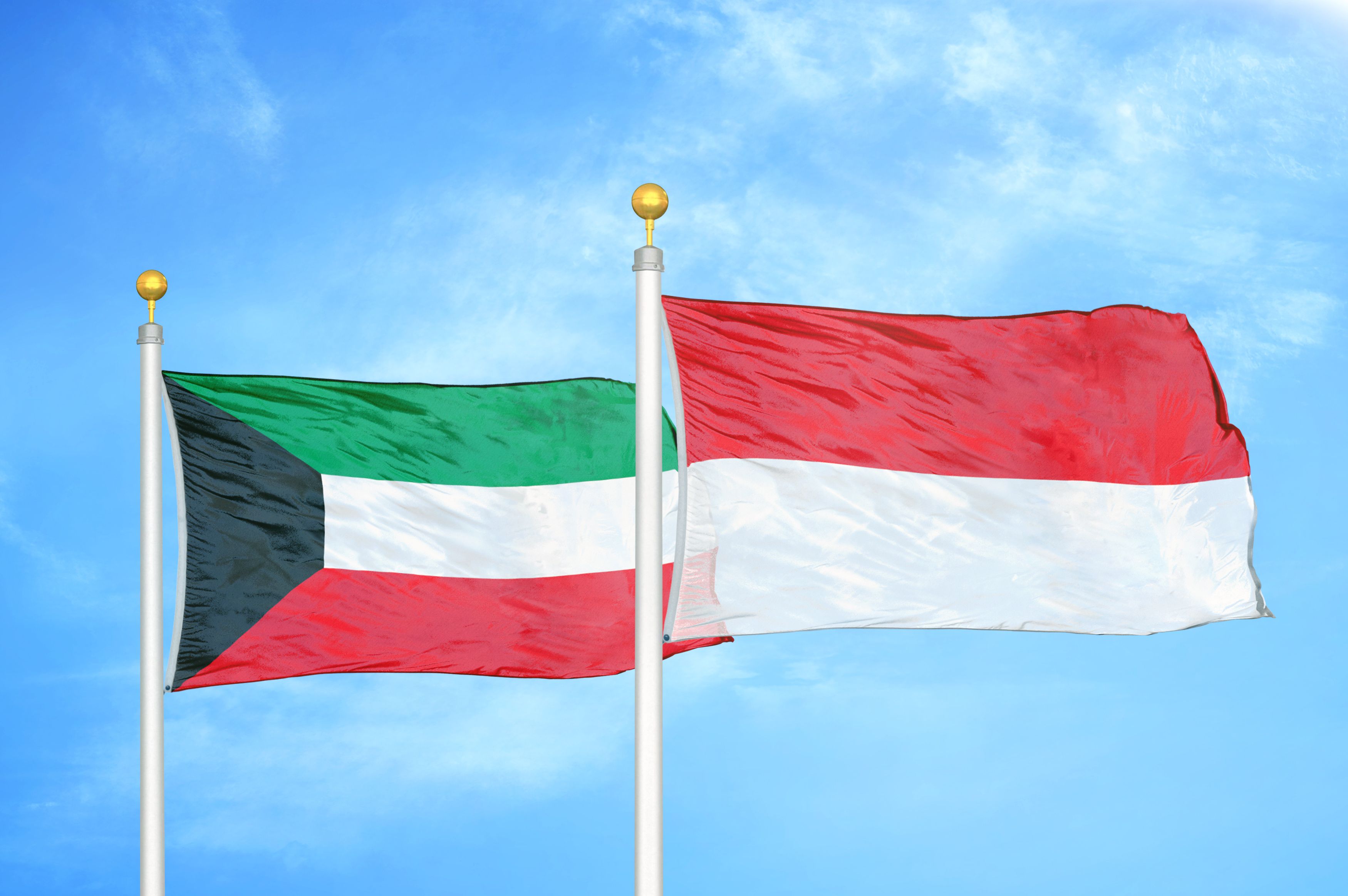 Kuwait And Indonesia Two Flags On Flagpoles And Blue Cloudy Sky