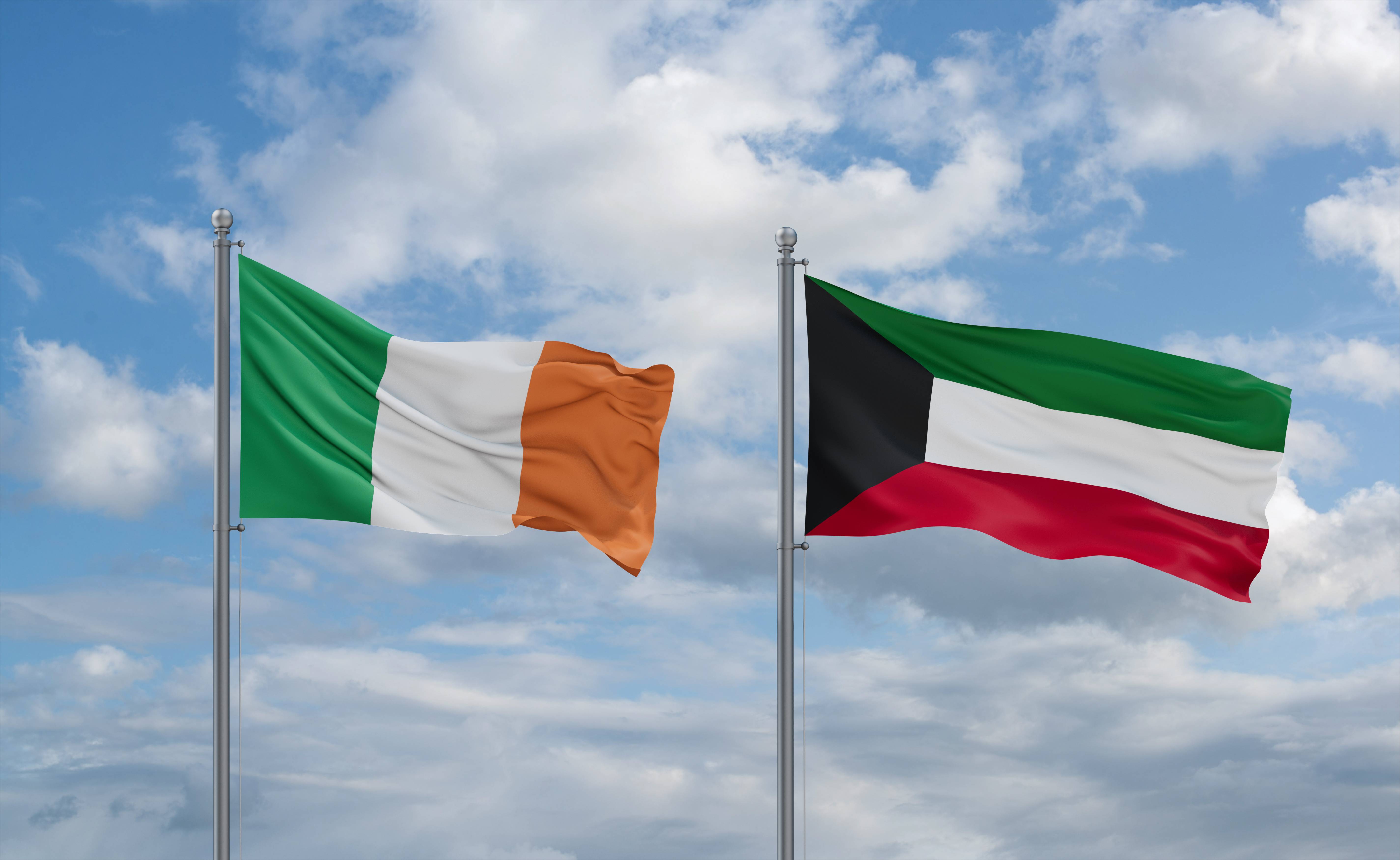 Kuwait And Ireland Flags Waving Together In The Wind On Blue Cloudy Sky