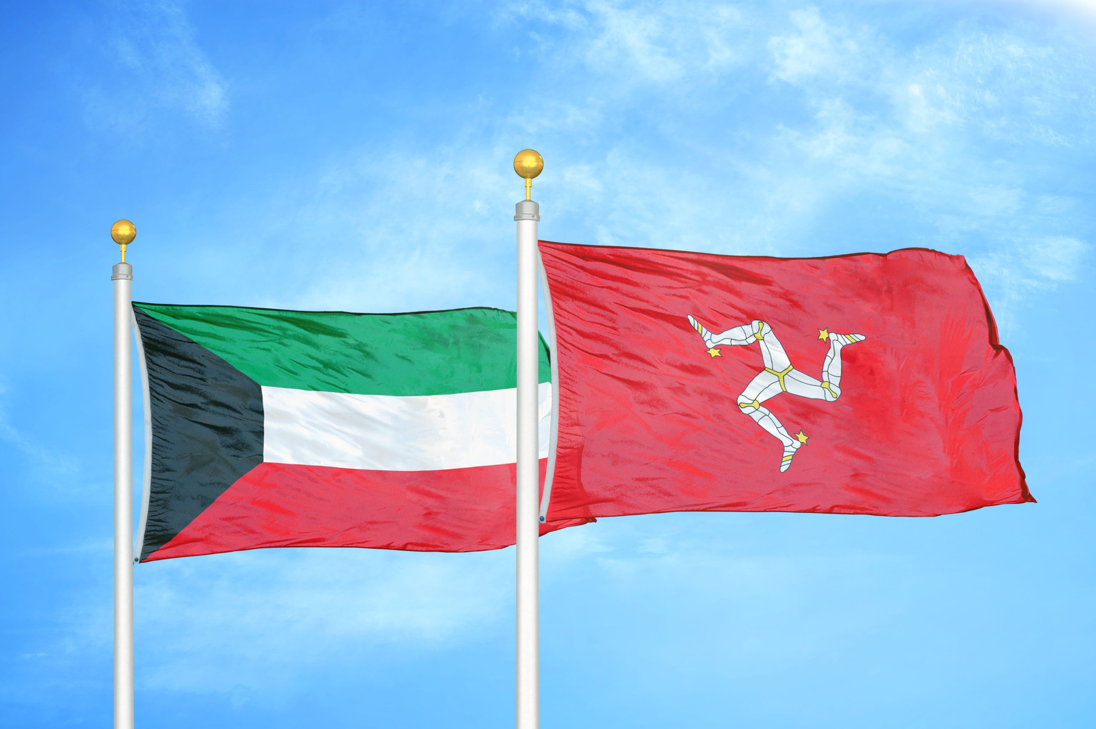 Kuwait And Isle Of Mann Two Flags On Flagpoles And Blue Cloudy Sky Background