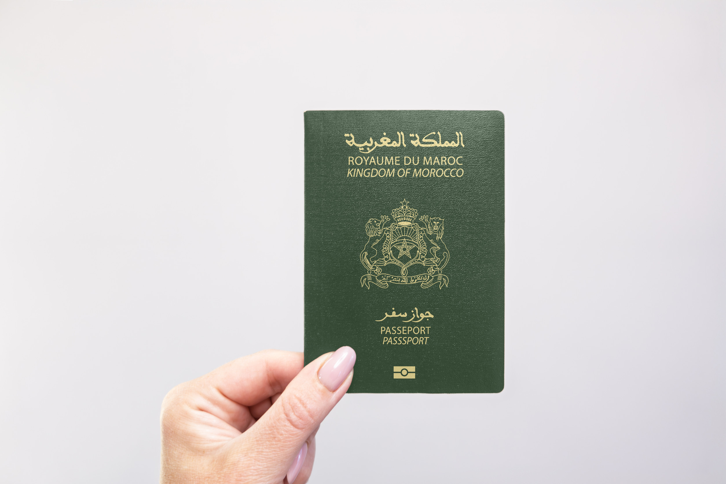 Morocco Passport Held In Hand Against A Plain