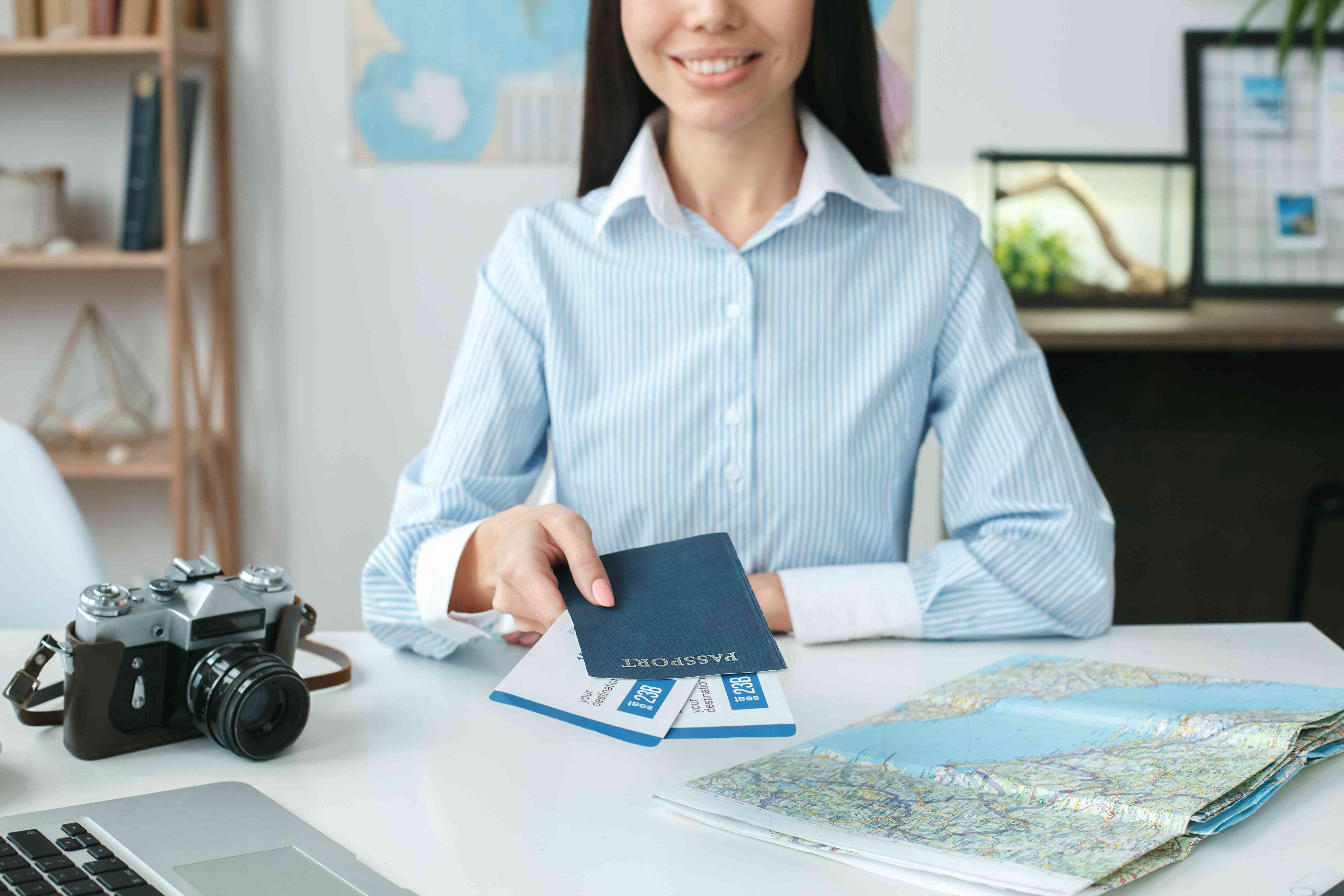 Young Female Travel Agent Consultant In Tour Agency Holding Documents